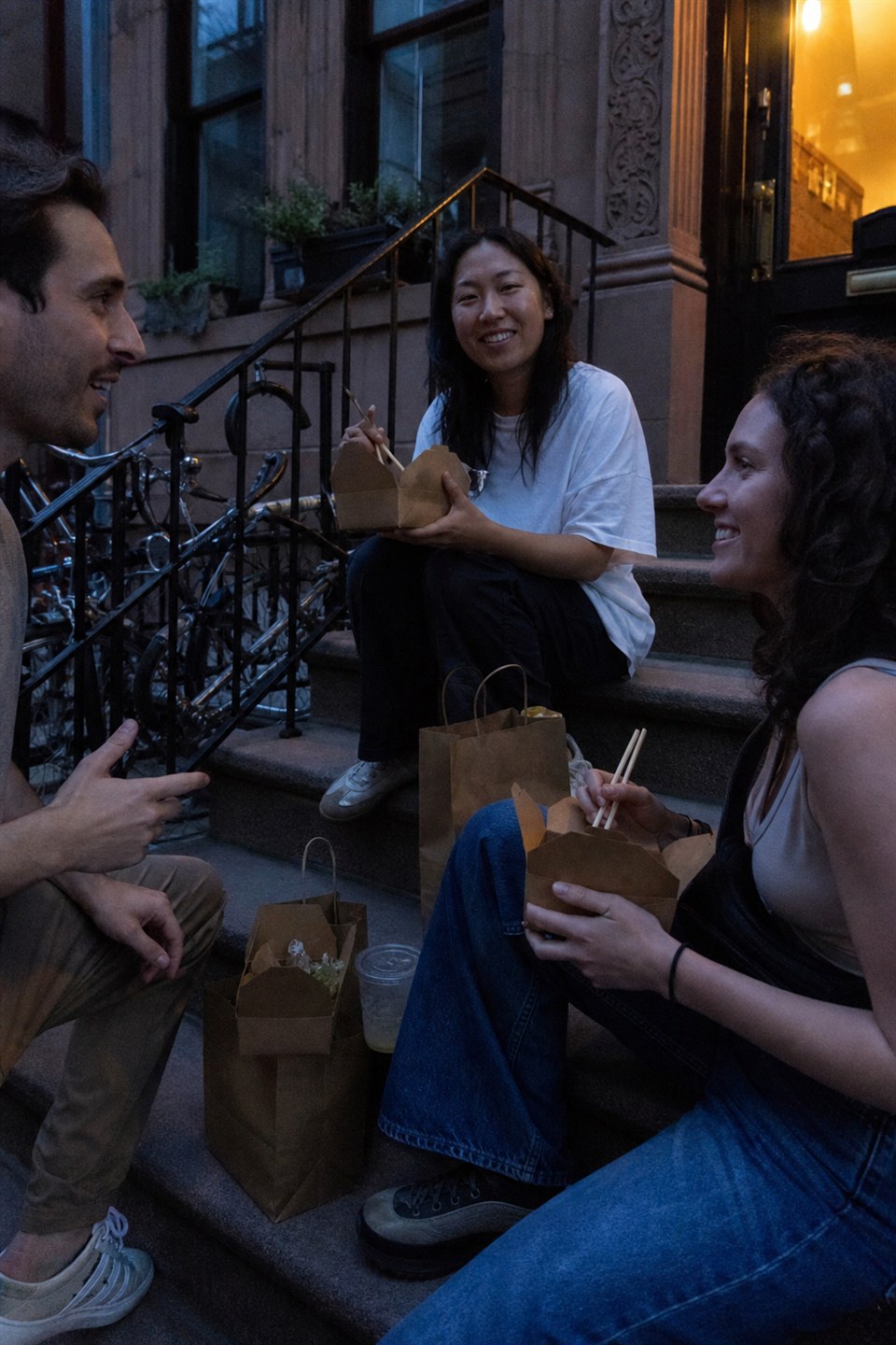 Friends having takeout together on a stoop